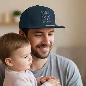 Personalisierte Papa Cap EST 2026 als stylisches Snapback Cap Herren, ideales Geschenk für Papa zum Geburtstag oder als Weihnachtsgeschenk Papa. Cooles Papa Cap mit personalisierbarem Frontdruck, perfekt als Geschenkidee für werdenden Papa, Vatertagsgeschenk oder Geschenk für Männer Papa. Hochwertige Papa Cappy aus 100 % Baumwoll-Twill, bequem & verstellbar. Moderne Dad Cap als Geschenk für Papa Geburtstag, Weihnachten Papa Geschenk Vater und persönliches Papa Geschenk.