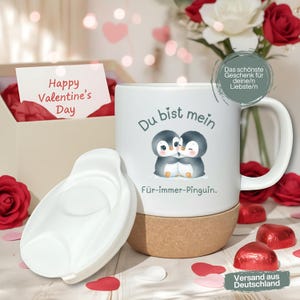 Könnte beinhalten: Weiße Keramik-Tasse mit Korkboden, mit einer Pinguin-Paar-Illustration und dem Text "Du bist mein Für-immer-Pinguin." Ein weißer Deckel liegt daneben. Eine Karte zeigt "Happy Valentine's Day."