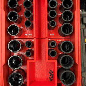 Könnte beinhalten: Rote Werkzeugkiste mit transparentem Deckel, gefüllt mit schwarzen Steckschlüsseln in verschiedenen Größen. Die Steckschlüssel sind in einer roten Ablage angeordnet, mit den Bezeichnungen "METRIC" und "SAE". Enthält ein kleines Fach mit Schrauben.