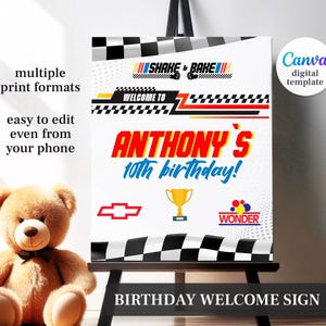 May include: A birthday welcome sign with a racing theme. The sign features the text "Anthony's 10th birthday!" in red and yellow, along with racing flags and a gold trophy. The sign is on a black easel.
