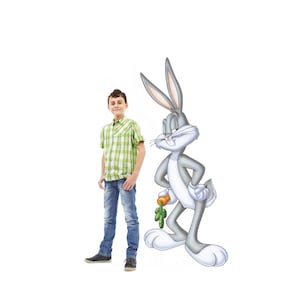 May include: A young person stands next to a cartoon character, Bugs Bunny. The person is wearing a green and white plaid shirt, blue jeans, and black shoes. Bugs Bunny is gray with long ears, holding a carrot.