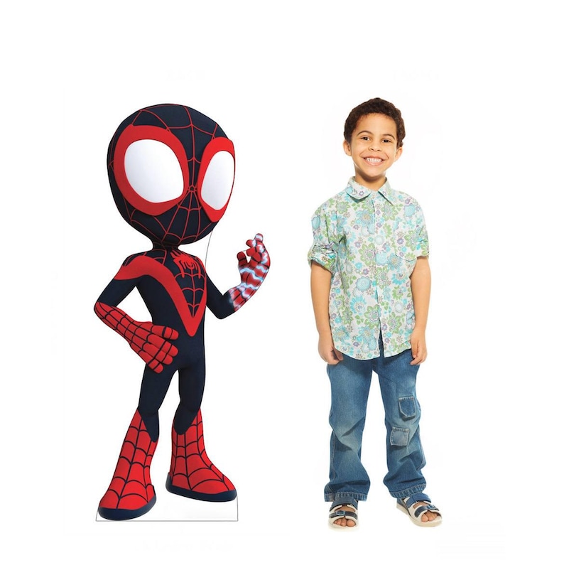 Puede incluir: Un recorte de dibujos animados de Miles Morales, el personaje de Spider-Man, con un traje negro y rojo. Un ni&ntilde;o peque&ntilde;o con una camisa con botones de flores y vaqueros azules est&aacute; de pie junto al recorte. El fondo es blanco.