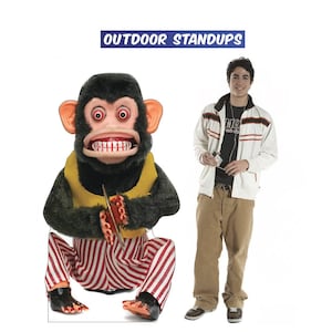May include: A life-size, vintage-style mechanical monkey standup with a yellow vest and red and white striped pants. The monkey holds a pair of cymbals. The text "OUTDOOR STANDUPS" is displayed above the monkey.