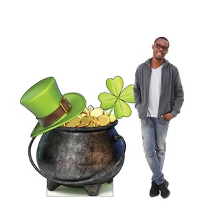 May include: A St. Patrick's Day themed image featuring a black cauldron overflowing with gold coins, a green leprechaun hat, and a four-leaf clover. A person stands to the right of the cauldron.
