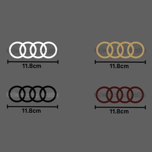 May include: Four decals featuring the interlocking rings logo, each 11.8cm wide. The logos are white, gold, black, and maroon. The decals are displayed against a gray background.