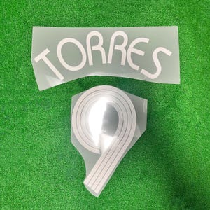 May include: White iron-on letters spelling "TORRES" and a white iron-on number "9" on a green background.