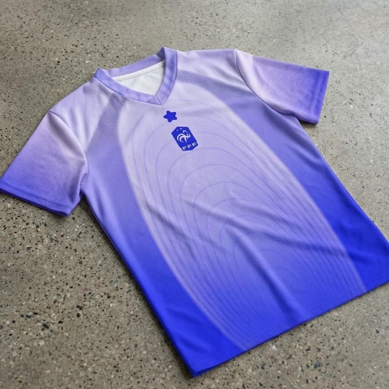 Pode incluir: Uma camisa de futebol roxa e azul com decote em V e mangas curtas. A camisa apresenta um design gradiente e um bras&atilde;o com uma estrela e as letras "FFF". A camisa &eacute; feita de um material leve.