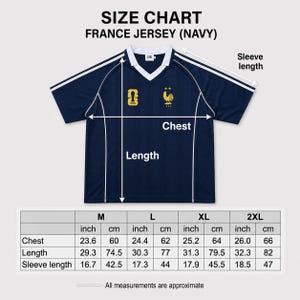 Pu&ograve; includere: Una maglia blu navy con scollo a V, bordini bianchi e strisce bianche sulle spalle. Sul petto sono presenti un logo giallo e un emblema di un gallo giallo. Una tabella taglie mostra le misure in cm per torace, lunghezza e maniche da M a 2XL.