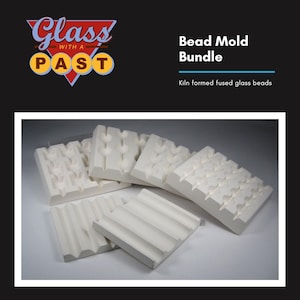 May include: A set of five white ceramic bead molds for making kiln-formed fused glass beads. The molds are arranged in a semi-circle with the largest mold in the back and the smallest mold in the front. The molds have different patterns and sizes.