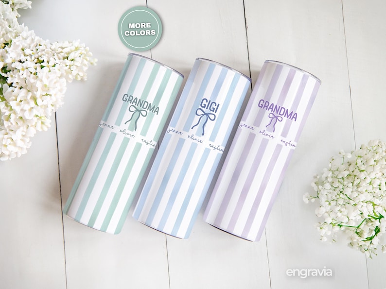 May include: Three personalized tumblers with vertical striped patterns in mint green, light blue, and lavender. Each tumbler has a name and bow graphic. The text on the tumblers reads "GRANDMA" and "GIGI".