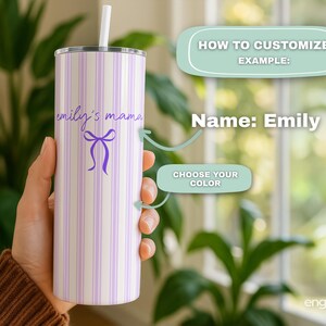May include: A personalized tumbler with a white and lavender striped pattern. The tumbler features the text "emily's mama" in a script font, along with a purple bow graphic. It includes a white straw and a silver lid.