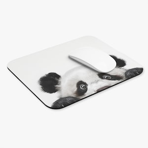 May include: A white mouse mat with a black border, featuring a panda bear design. A white computer mouse sits on the mat. The panda's face is in black and white.