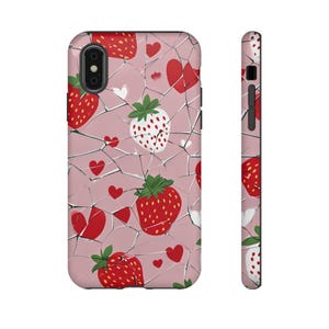 Puede incluir: Una funda de teléfono rosa con un diseño de vidrio roto y un patrón de fresas rojas y corazones.