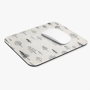 May include: A rectangular mouse mat with a cream background and a black tree branch pattern. A white computer mouse sits on the mat. The mouse mat has a black border.