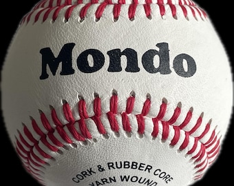 May include: A white baseball with red stitching and the word "Mondo" printed in black. The baseball has the text "Cork & Rubber Core Yarn Wound" and "Full Grain Leather Cover 5 oz 9 in".
