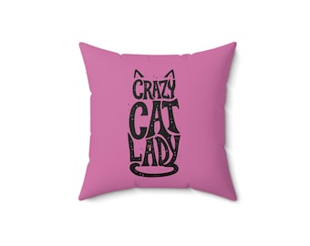 May include: Pink throw pillow with a black cat silhouette and the text "crazy cat lady" printed on it.
