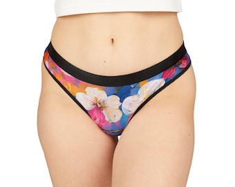 May include: Floral print underwear with a black waistband. The print features pink, white, and yellow flowers on a blue background.