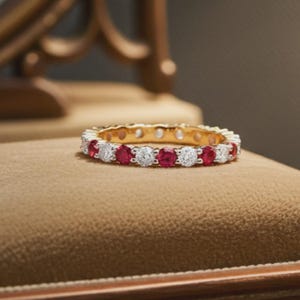 Peut inclure: Une bague alliance en or ornée d'un motif alterné de rubis rouges ronds et de diamants blancs transparents, sertis en une rangée continue sur toute la circonférence de l'anneau métallique, présentant une finition polie et des couleurs vives.