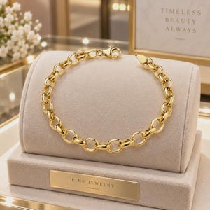 Puede incluir: Una pulsera de cadena de oro amarillo pulido con eslabones gruesos y redondeados entrelazados. La pulsera se asegura con un cierre de mosquetón y se exhibe en un soporte de joyería de terciopelo beige con una placa dorada FINE JEWELRY.