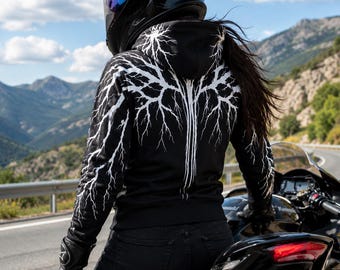 Puede incluir: Una sudadera negra con capucha que presenta un patrón gráfico de rayos blancos en la espalda y las mangas, usada con jeans negros y guantes de moto negros, junto con un casco de moto integral negro con una visera tintada oscura.