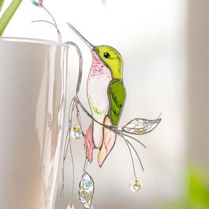 Elegant stained glass green hummingbird plant decor with sparkling crystals.