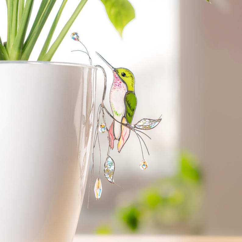Elegant stained glass green hummingbird plant decor with sparkling crystals.