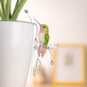 Dreamy green hummingbird stake with crystals – a glowing touch for plant lovers.