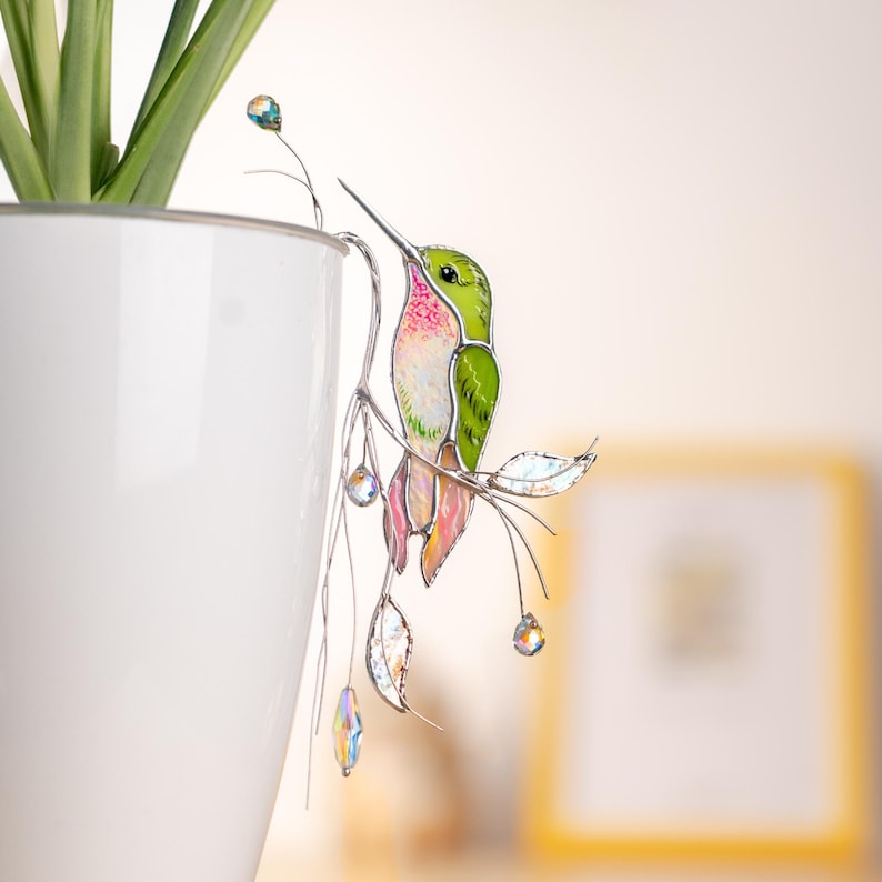Dreamy green hummingbird stake with crystals – a glowing touch for plant lovers.