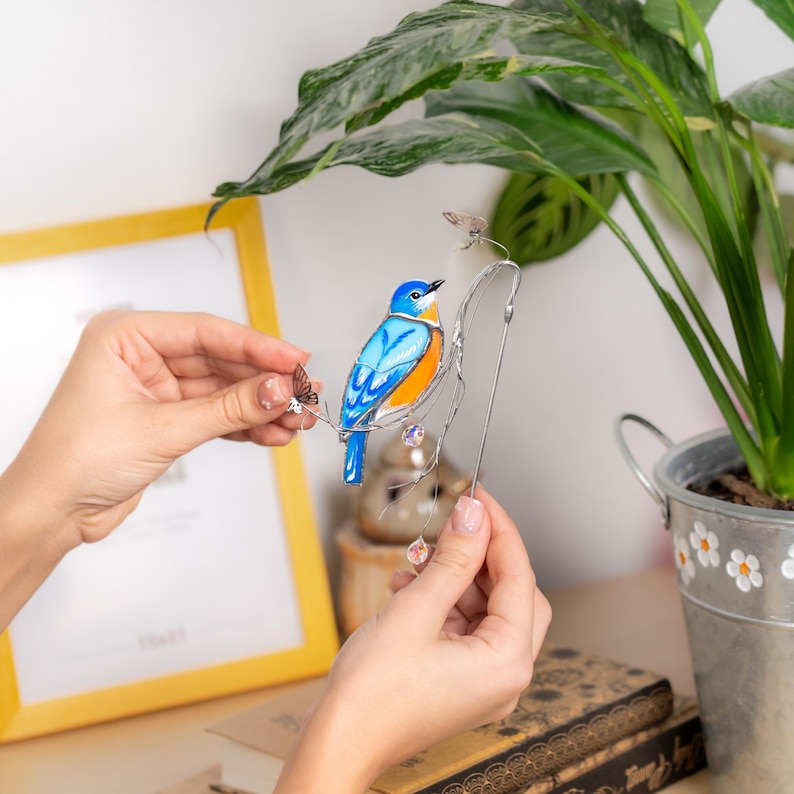 Graceful bluebird plant pot decor – a charming mix of stained glass, crystals, and butterflies.