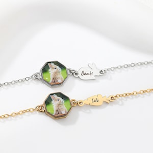 May include: Two delicate bracelets. One silver, the other gold. Each has a small, octagonal charm with a rabbit image. The silver bracelet has a bunny-shaped charm with the name "Bambi." The gold bracelet has a carrot-shaped charm with the name "Lulu."