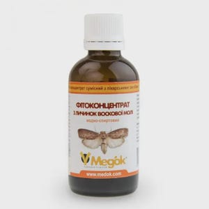 Puede incluir: Una botella de vidrio marrón con tapa blanca y una etiqueta con una ilustración de polilla. La etiqueta incluye texto en ucraniano y la dirección del sitio web www.medok.com.