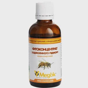 May include: A brown glass bottle with a white cap and a label featuring a bee illustration. The label includes text in a foreign language and the brand name "Megok". The bottle is filled with a liquid.