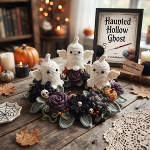 May include: A circular wreath featuring three crocheted white ghosts with black eyes, surrounded by dark purple and black crocheted flowers, small orange pumpkins, green leaves, and miniature skulls. A framed sign reads Haunted Hollow Ghost.