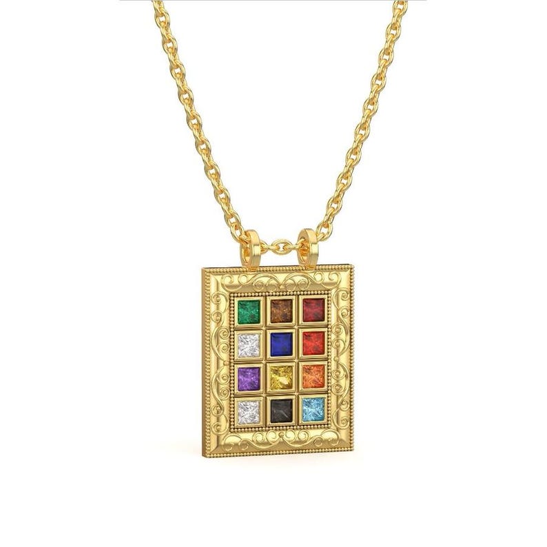 Pu&ograve; includere: Una collana d'oro con un ciondolo che presenta una cornice quadrata con 12 pietre preziose colorate. Il ciondolo ha un design elaborato ed &egrave; su una catena delicata.