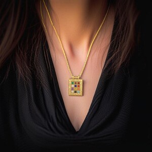 Pu&ograve; includere: Una collana con catena d'oro con un ciondolo quadrato che presenta una griglia di pietre preziose colorate. Il ciondolo &egrave; ornato e ha un bordo dettagliato.