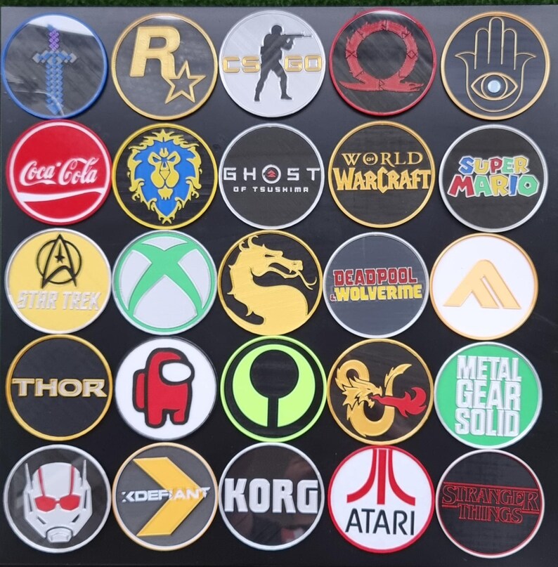 May include: A collection of 25 round embroidered patches featuring various video game, movie, and pop culture logos. The patches are arranged in a grid pattern on a black background. Some of the logos include Star Trek, Coca-Cola, Ghost of Tsushima, World of Warcraft, Super Mario, Thor, Metal Gear Solid, and Stranger Things.
