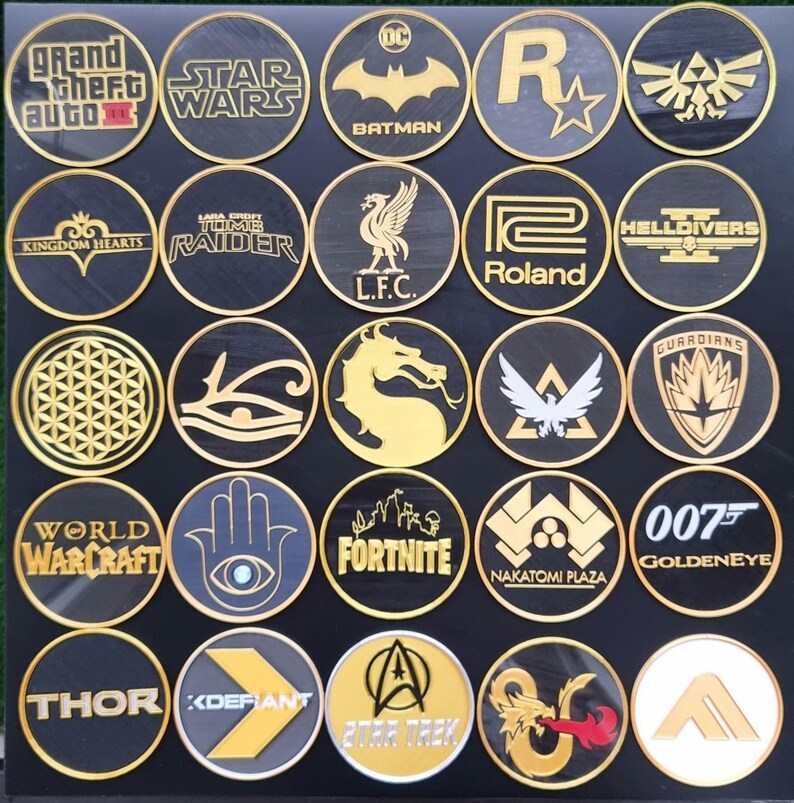 May include: A collection of 20 round, black and gold embroidered patches featuring various logos and designs. The patches include logos for popular video games, movies, and sports teams. Some of the logos include: Grand Theft Auto, Star Wars, Batman, Kingdom Hearts, Lara Croft Tomb Raider, L.F.C., Roland, World of Warcraft, Fortnite, 007 Goldeneye, Thor, and Star Trek.