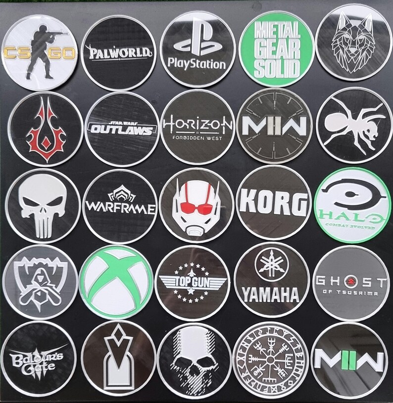 May include: A collection of 20 round, black and white stickers with various video game, movie, and brand logos. The logos include: CS:GO, Palworld, PlayStation, Metal Gear Solid, Horizon Forbidden West, Korg, Halo, Warframe, Ghost of Tsushima, Yamaha, Top Gun, MIN, Outlaws,  and more.