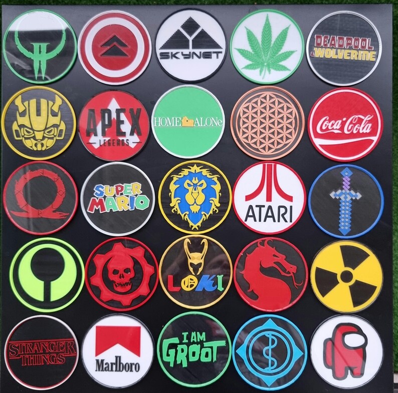 May include: A collection of 25 round iron-on patches featuring various logos and designs. The patches are colorful and include logos such as Coca-Cola, Apex Legends, Super Mario, and Stranger Things.