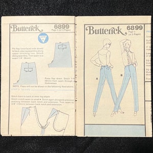 May include: A sewing pattern for trousers with instructions on how to sew the seams. The pattern includes two figures wearing the trousers, one in blue and one in light blue. The pattern is for size 6899.