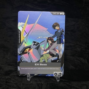 May include: A holographic trading card featuring anime characters and a mecha. The card has the text "EX Base" and "EXB-028". The card is displayed on a clear plastic stand.