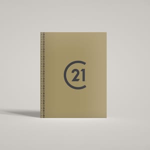 May include: A tan-coloured rectangular sign featuring the number "21" within a dark grey circle. The letters "EN" and "UR" are printed vertically along the left edge of the sign.