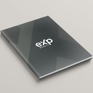 May include: A dark gray notebook with the text "eXp REALTY" in white. The notebook has a glossy finish and a white border. The cover features a geometric design.