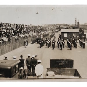 Antike RPPC Marineparade Postkarte 1928 - 1933 Militärkapelle Truppeninspektion Union Jack Flagge am Kai große Menschenmenge Vintage Hochglanzfoto Ephemera