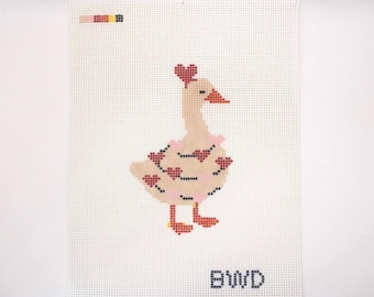 May include: Needlepoint canvas featuring a goose design. The goose is light tan with red heart accents on its body and a heart on its head. It has a pink ruffle around its neck and red feet. The letters "BWD" are at the bottom.