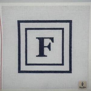 Könnte beinhalten: Weiße Leinwand mit dem marineblauen Buchstaben "F" in zwei marineblauen quadratischen Rahmen. Die Leinwand hat eine gitterartige Textur und ein kleines Logo in der unteren rechten Ecke.