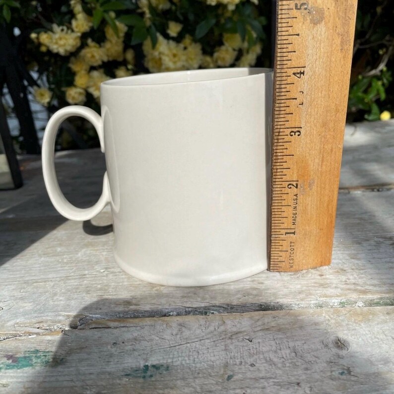 May include: A set of three ceramic mugs with a speckled, matte finish in cream, light grey, and dark grey. Each mug has a simple, modern design and a rounded handle.