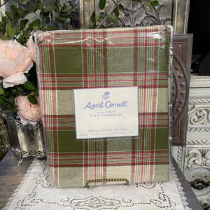 May include: A packaged bed sheet set with a plaid pattern in green, red, and white. The label reads "April Cornell" and "Exclusive Designs for C & F Enterprises, Inc."