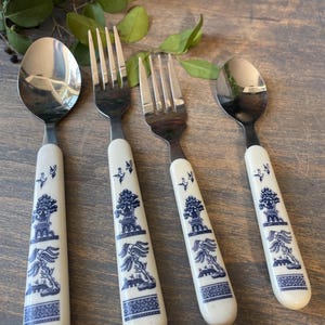 Puede incluir: Juego de cubiertos de cuatro piezas con dos tenedores y dos cucharas. Los mangos son de color blanco roto con un diseño azul de patrón Willow. Las cucharas y tenedores son de metal brillante y pulido.