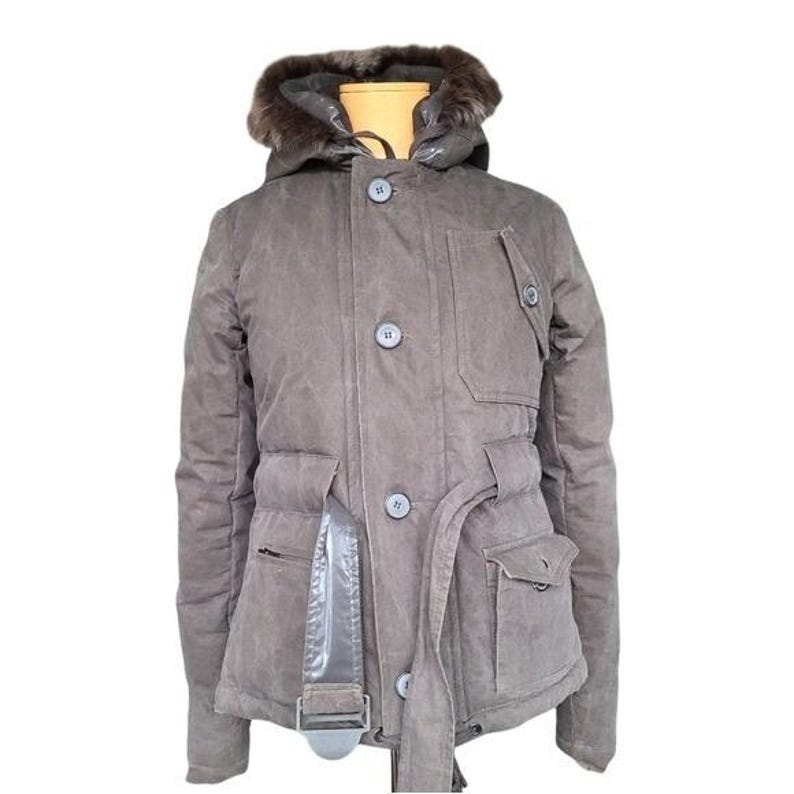 May include: A brown winter jacket with a fur-lined hood. The jacket has a button-up front, multiple pockets, and a belt. The jacket is made of a durable material and is designed for cold weather.